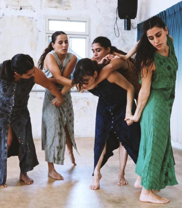 Dancers interlocking arms in a studio, Arabesque