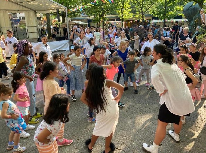 Bresa Ayub leading children in an outdoor dance class